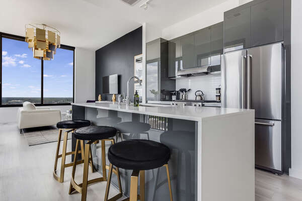 The kitchen Area Includes Two Black and Gold Stools for Seating.