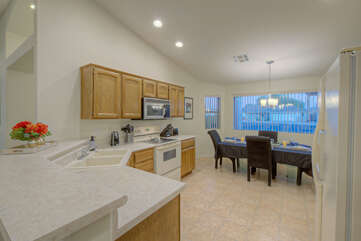 Kitchen opens into dining area with large windows.