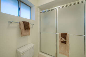Bath in primary suite has a walk-in shower with sliding doors.