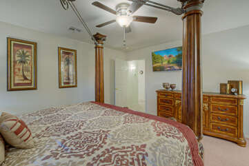 In addition to the grand king bed, the primary suite includes a ceiling fan, TV, walk-in closet and ensuite bath.