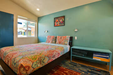Photo of the bed with side table and view of front door.