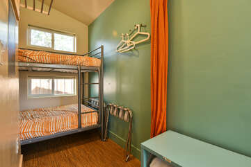 Bunk Beds in the back of the home, with curtain and metal frame.