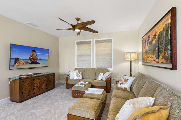 Wall-mounted TV, couches, and ottomans in the family area.
