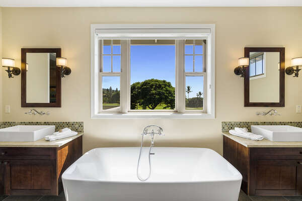 Master bathroom of this Kona Hawaii vacation rental with double vanity sinks and a large soaking tub.