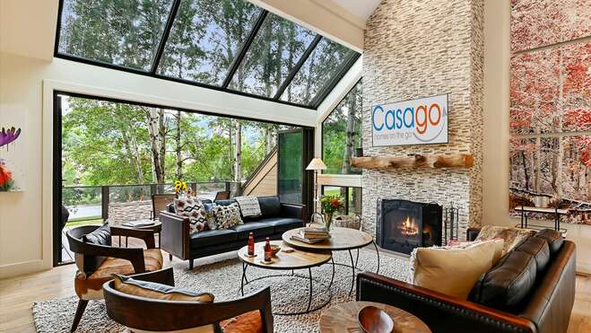 Living area boasts floor-to-ceiling windows, offering breathtaking natural light and lush outdoor views.