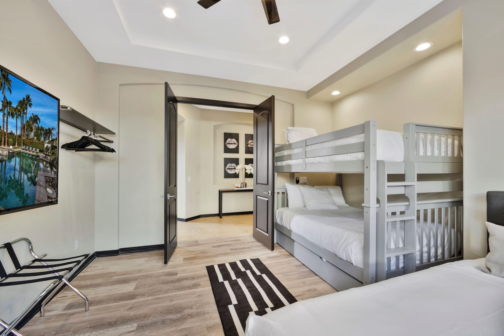 Bedroom 5 has large French doors and a 60-inch TV