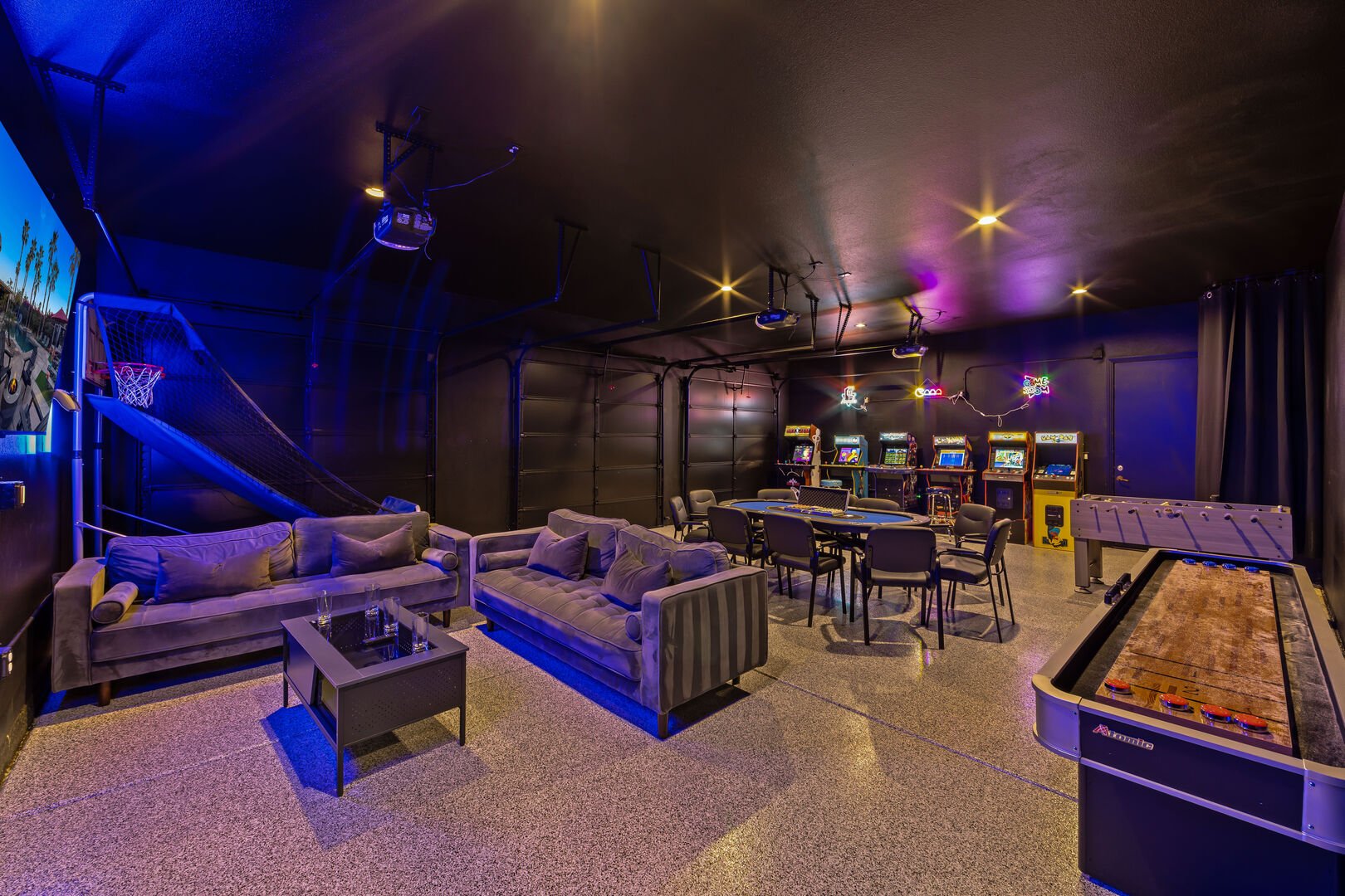 This game room features a large variety of arcades, foosball, shuffleboard, a large flat-screen TV, and a poker table!