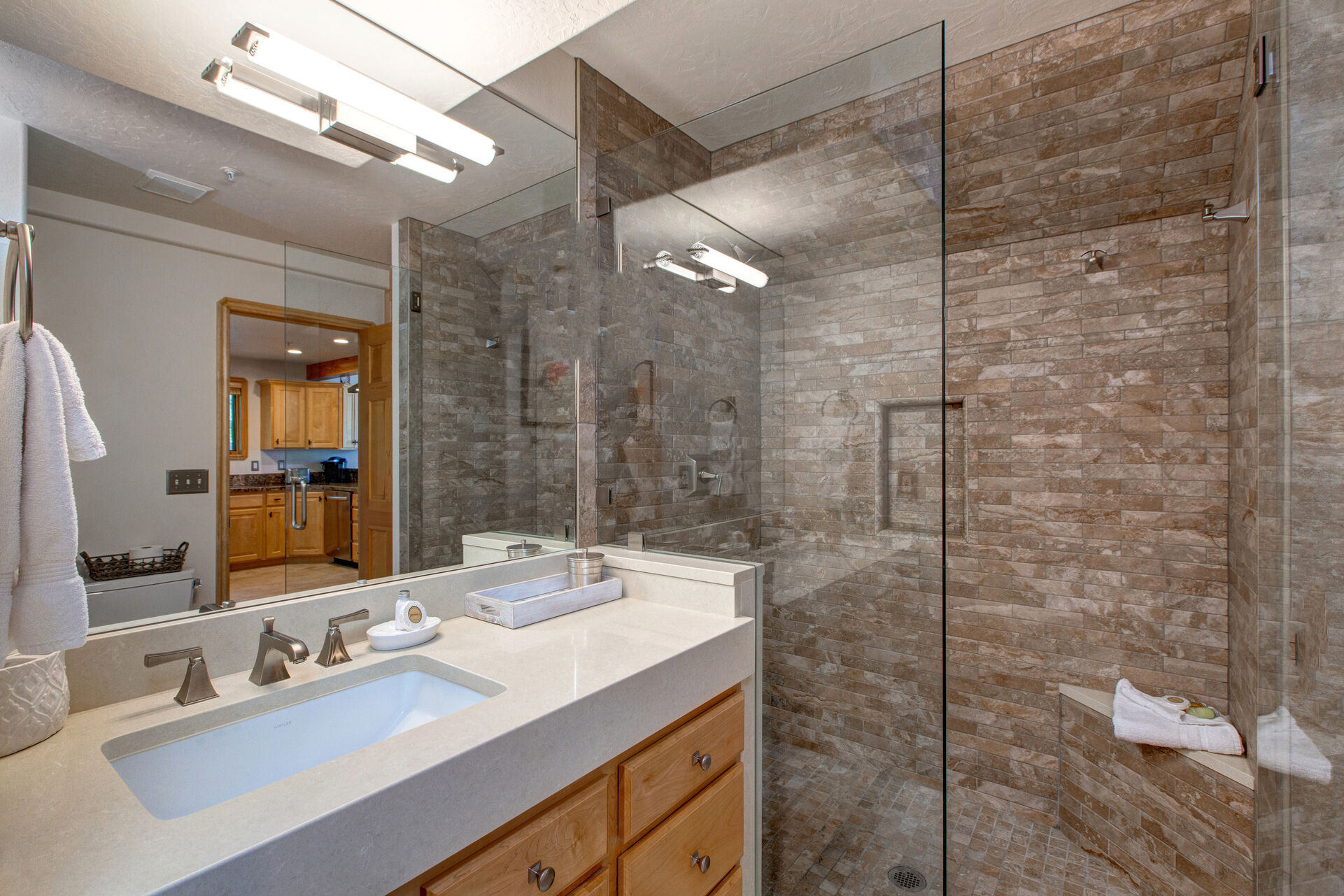 Main Level Shared Full Bathroom with a Quartz Counter Sink and Large Tiled Shower