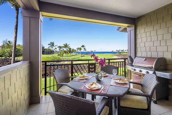 Private lanai of this Kona Hawaii vacation rental with golf course and ocean views, grill, and seating for 4.