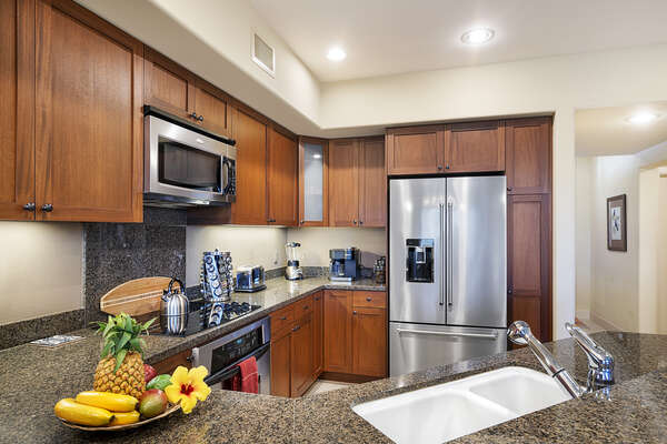 Fully equipped kitchen with fresh fruit on the counter.