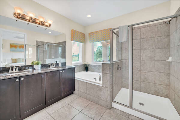 The ensuite bathroom features a walk in shower and a garden tub