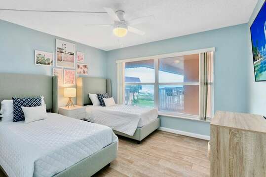 Guest bedroom with two twin beds, ocean view and a big screen TV