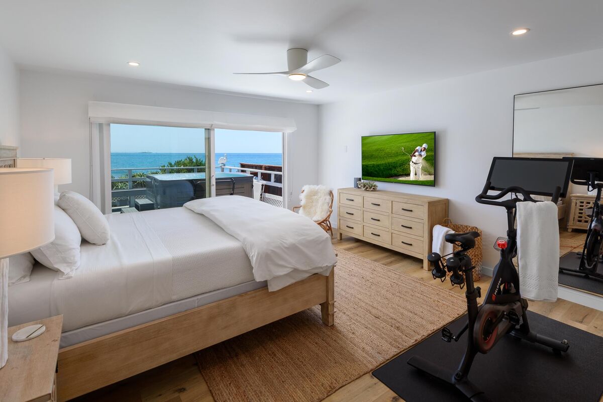 Primary suite with king-size bed, slider to the view deck, TV, ceiling fan, and Peloton,