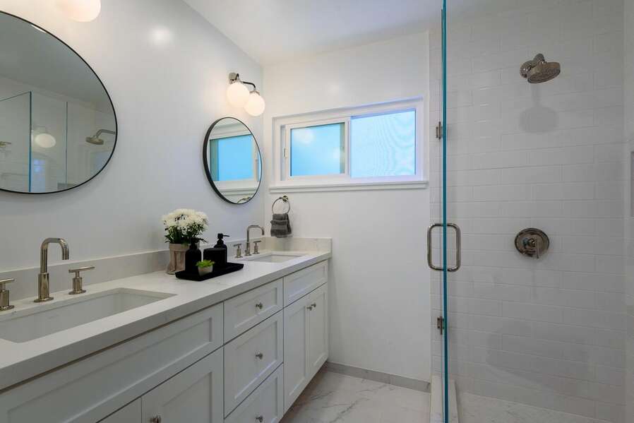 Primary ensuite bathroom with dual vanity sinks and walk-in shower