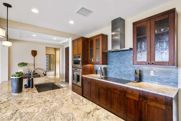 Fully equipped kitchen with in-island sink and oven range incorporated into the counter.