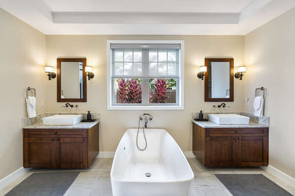 Primary bathroom with large tub and two vanity sinks.