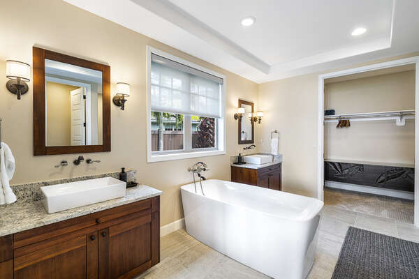 Spacious master bathroom with two vanity sinks on either side of a large soaking tub.