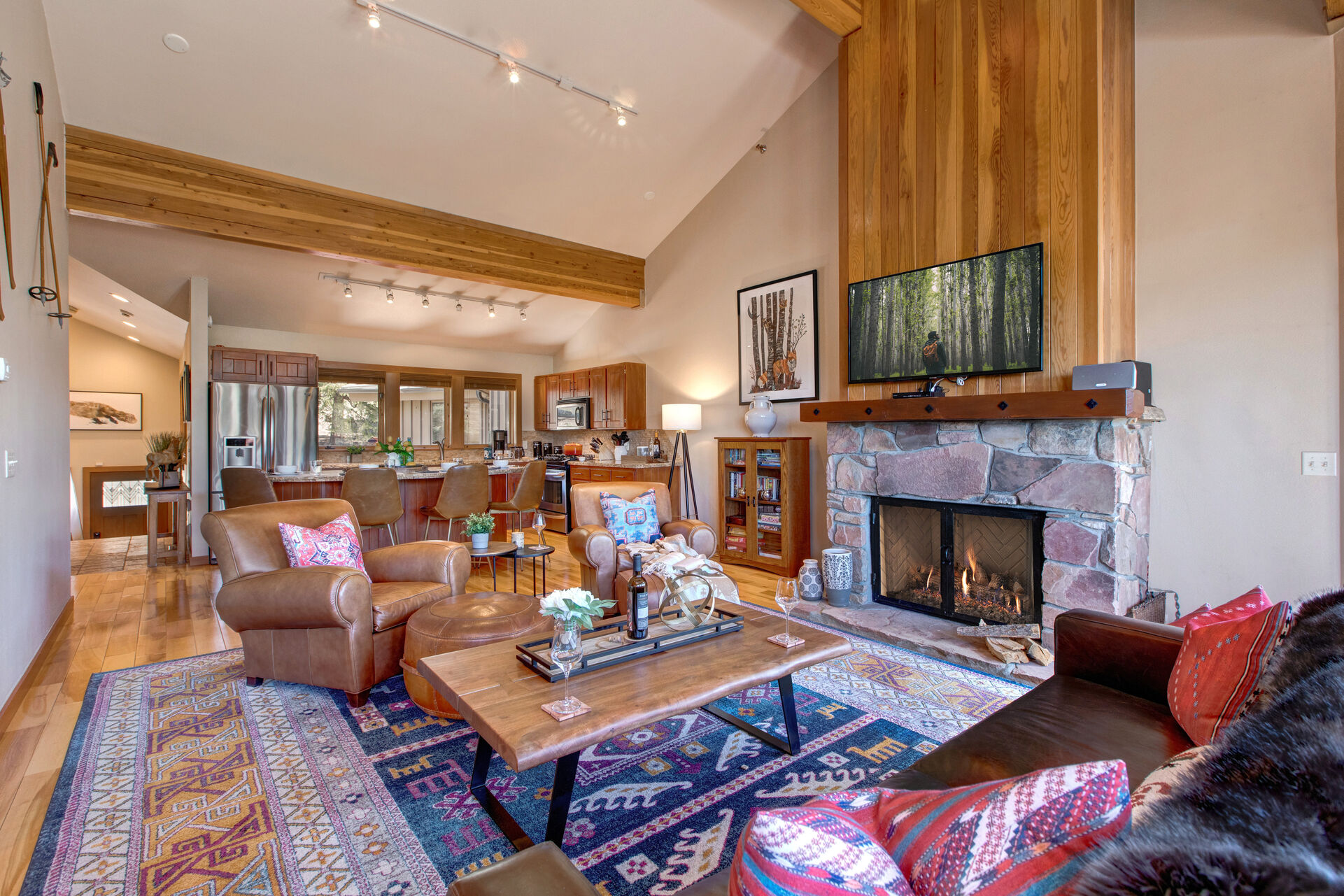 Great Room with Hardwood Flooring, a Vaulted Ceiling, Smart TV and a Warm Wood Burning Fireplace