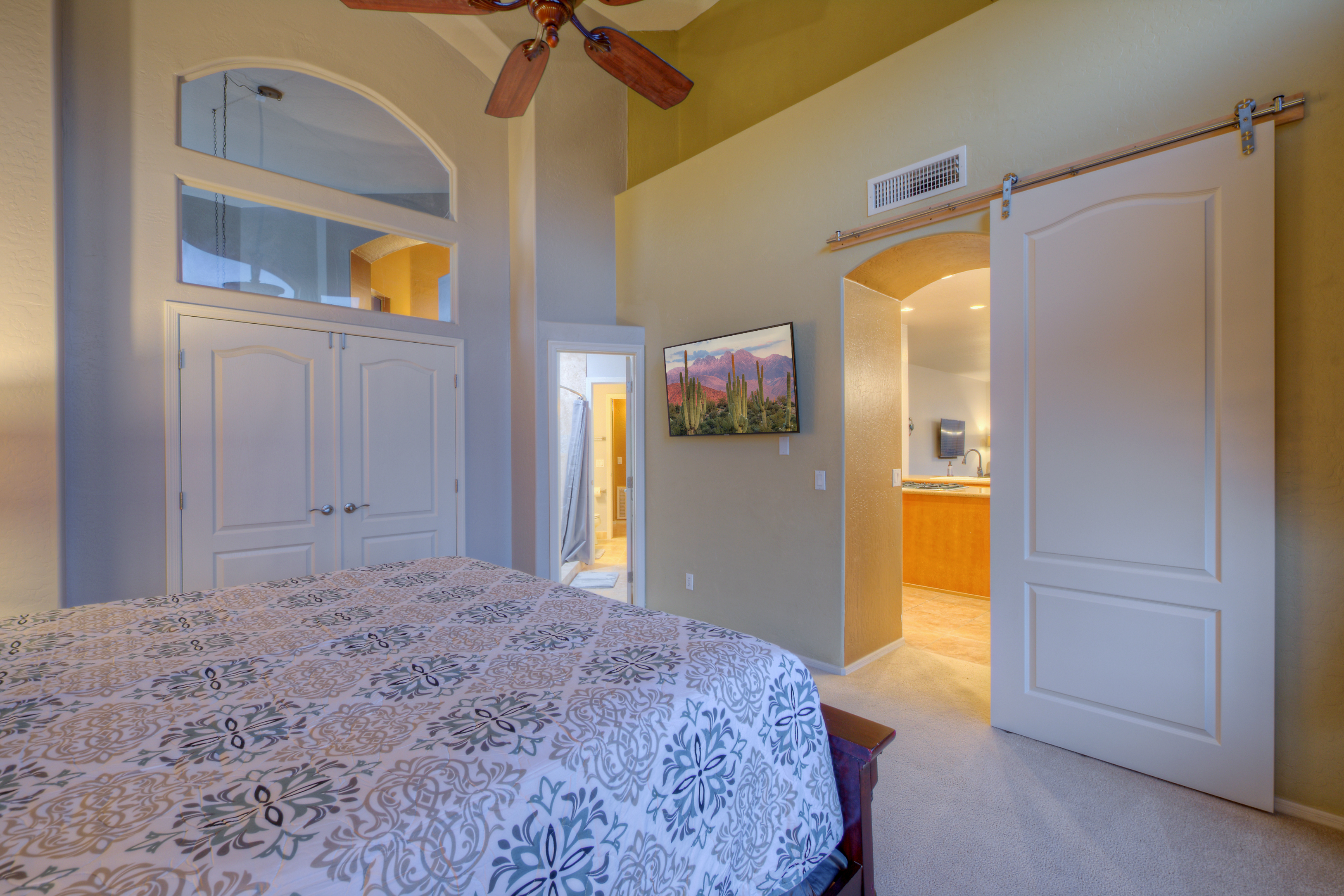 Exquisite 7th bedroom with king bed and TV is adjacent to the kitchen.