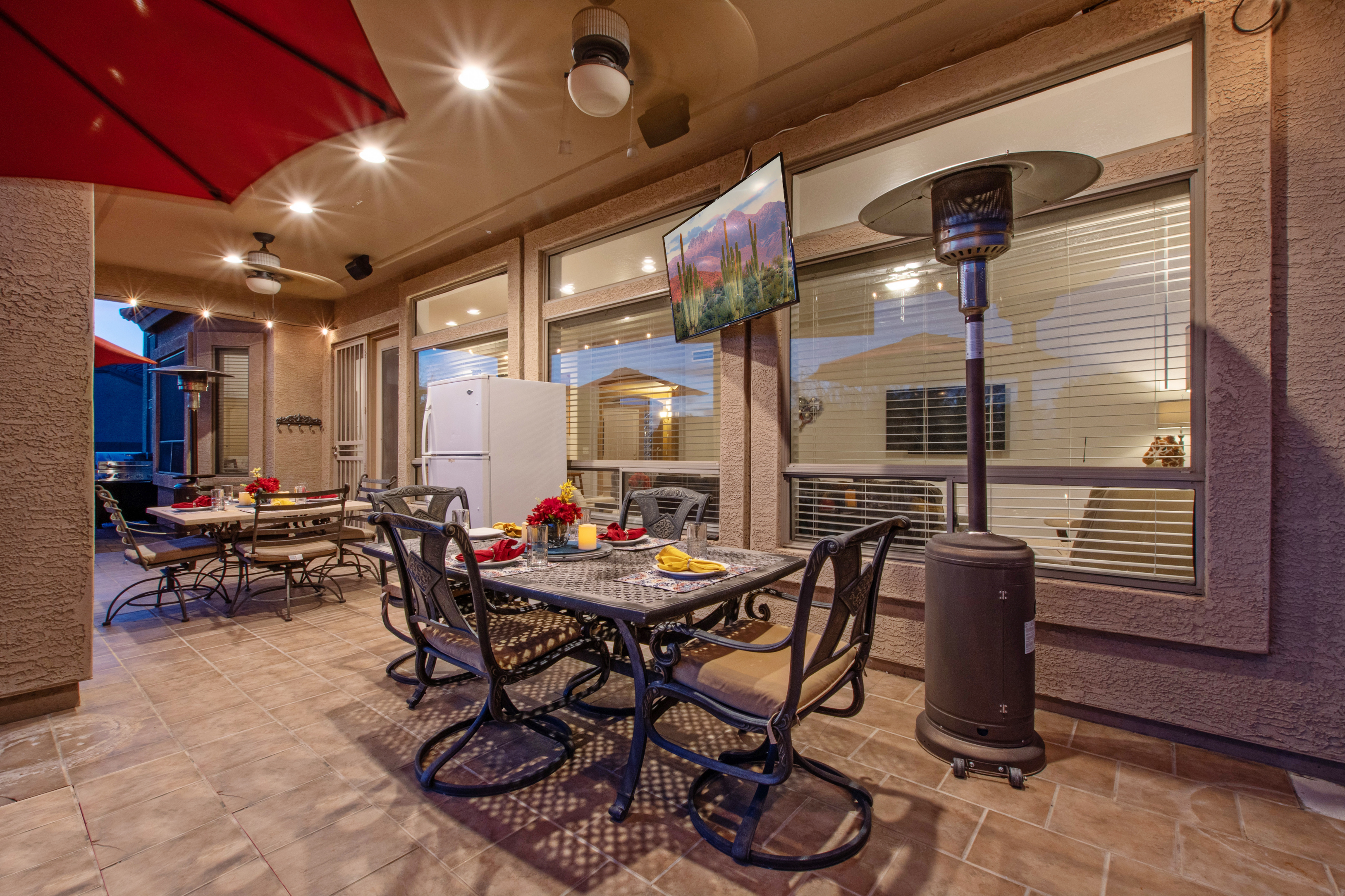 Large covered patio has dining furniture, a TV and free standing heaters for the occasional cool evening.