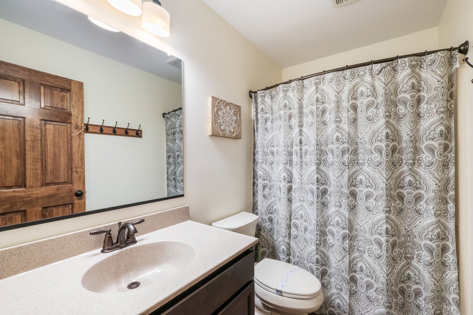 Bathroom with Toilet, Sink, and Shower with Curtain
