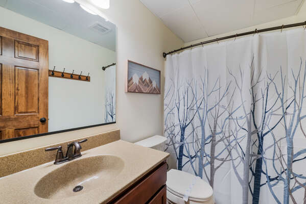 Bathroom with Sink, Toilet, and Shower with Winter Tree Curtain
