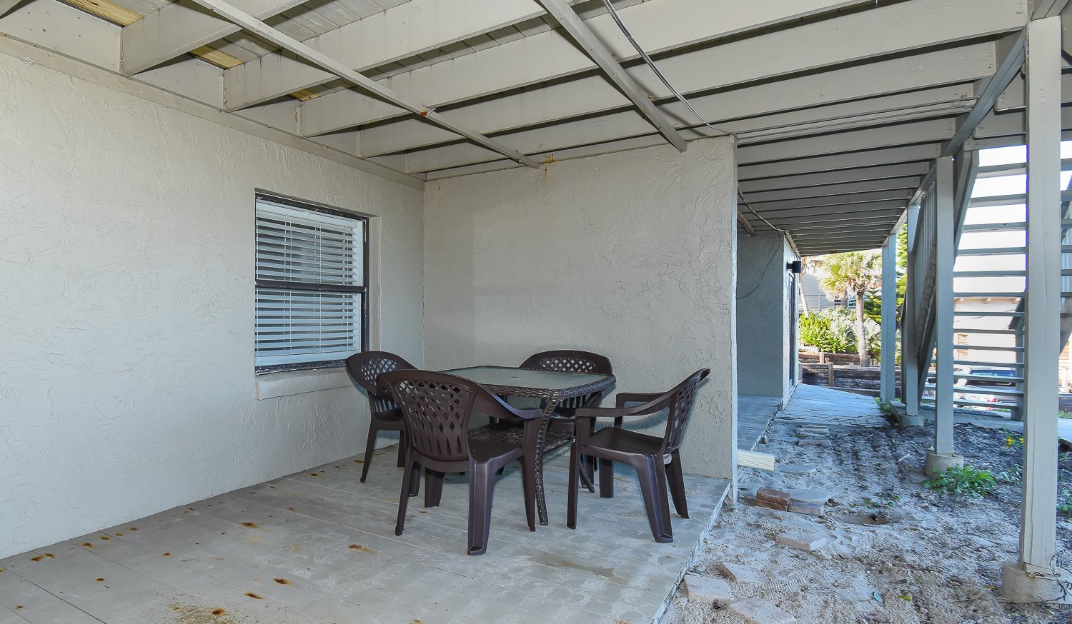 Covered patio with dining table and chairs