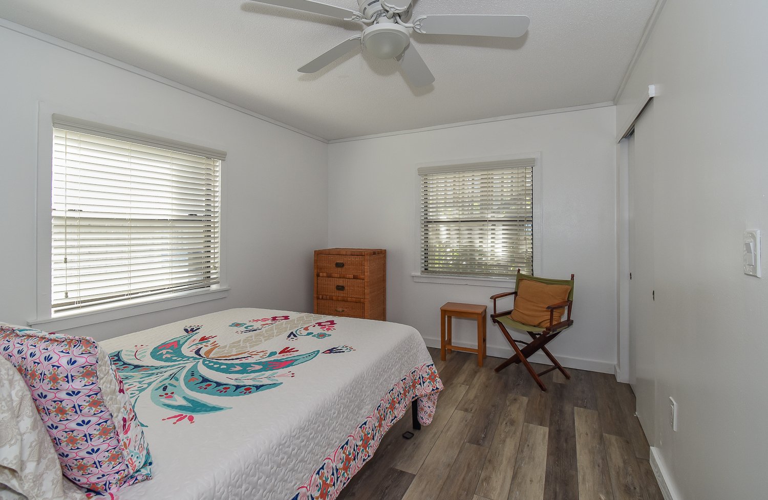Bedroom with large bed, dresser, and ceiling fan
