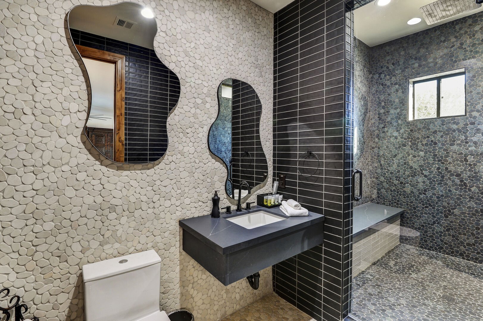 Indulge in convenience and style with the game room bathroom at Casa Palacio, offering a view into the standing shower.