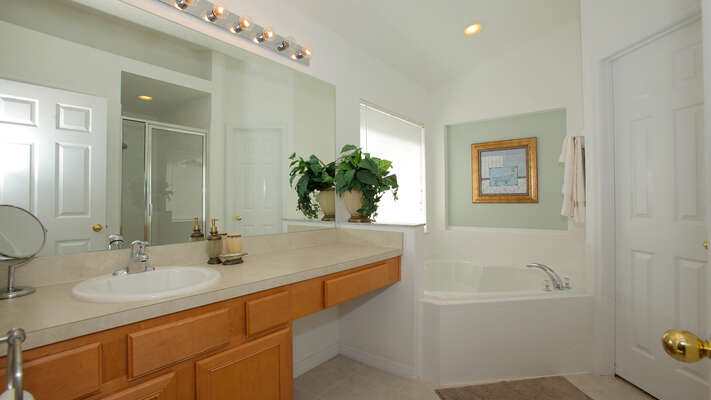 Master bedroom 1 en-suite has garden tub, separate glass shower and single vanity basin.