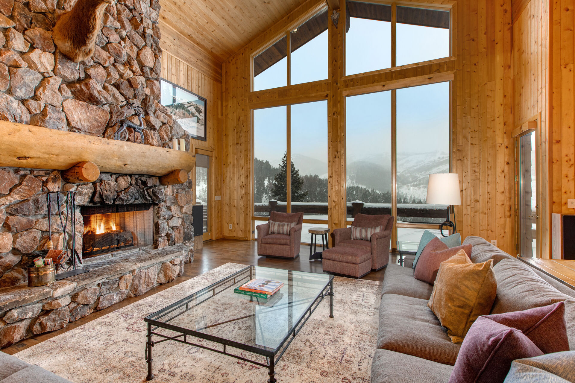 Living Room with Comfortable Furnishings, Wood Fireplace, Floor-to-Ceiling Windows, and Deck Access