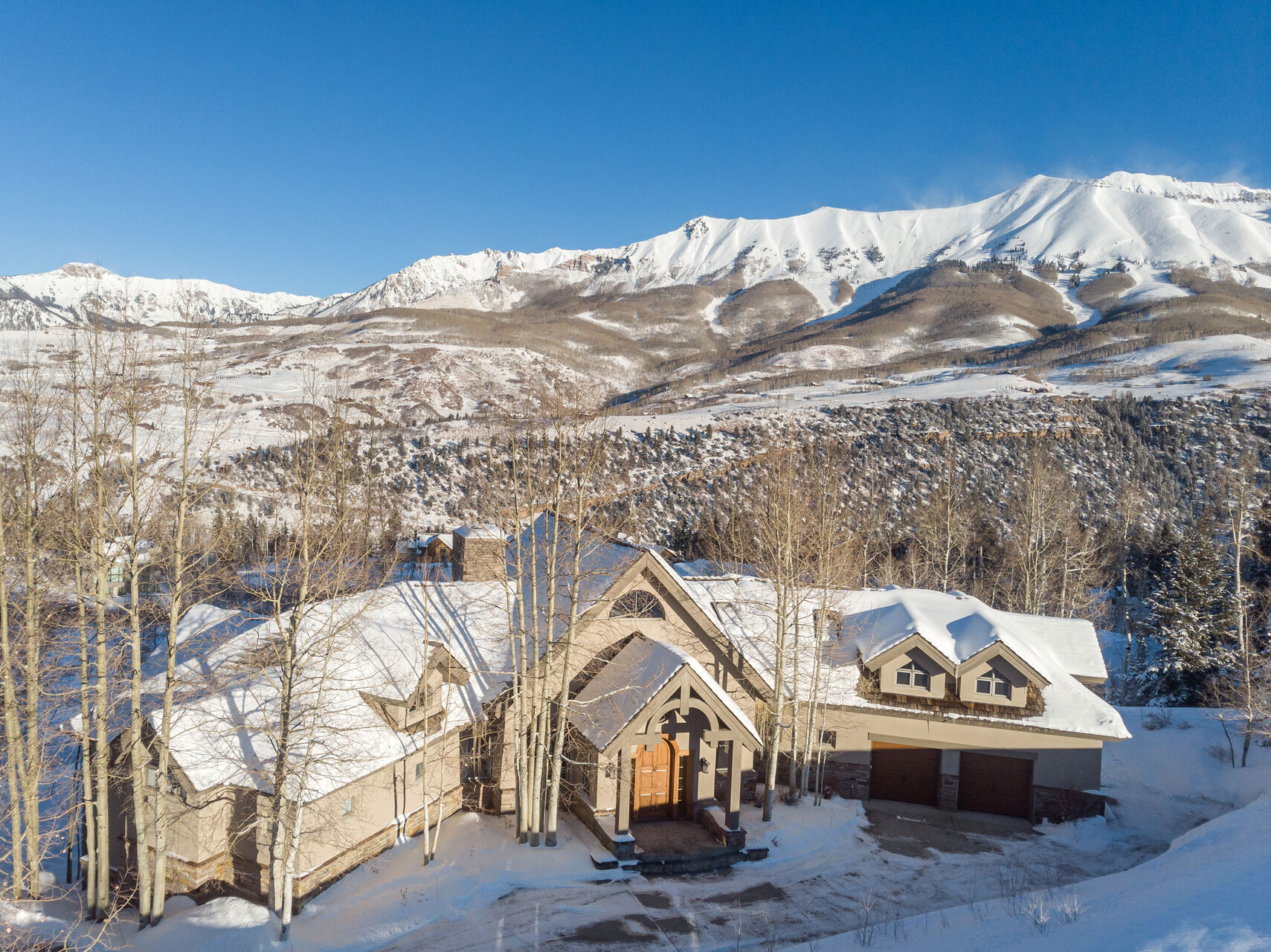 An aerial view of the snow-covered landscape around this Telluride golf rental.