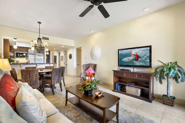 Wall-mounted TV sits above an entertainment center of the living room, in front of a coffee table and couch.
