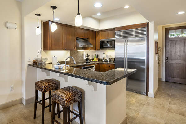Fully equipped kitchen with stainless steel appliances and breakfast bar.