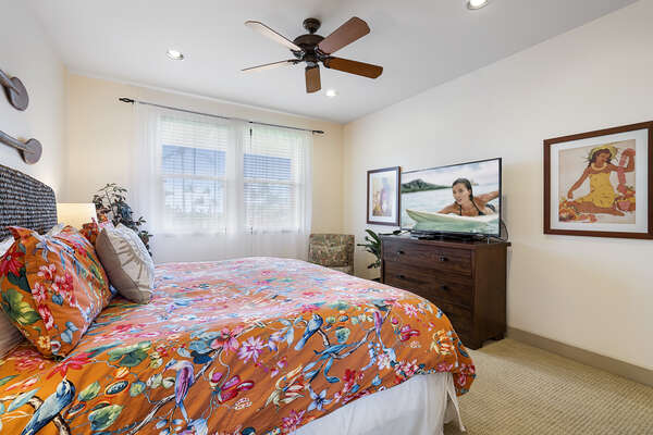 Large bed with dresser and flat-screen TV in the master bedroom.