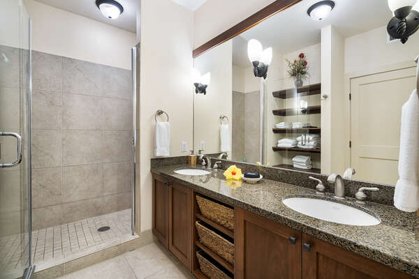 Primary bathroom of this Hali'i Kai condo with his and hers vanity sink and walk-in shower.