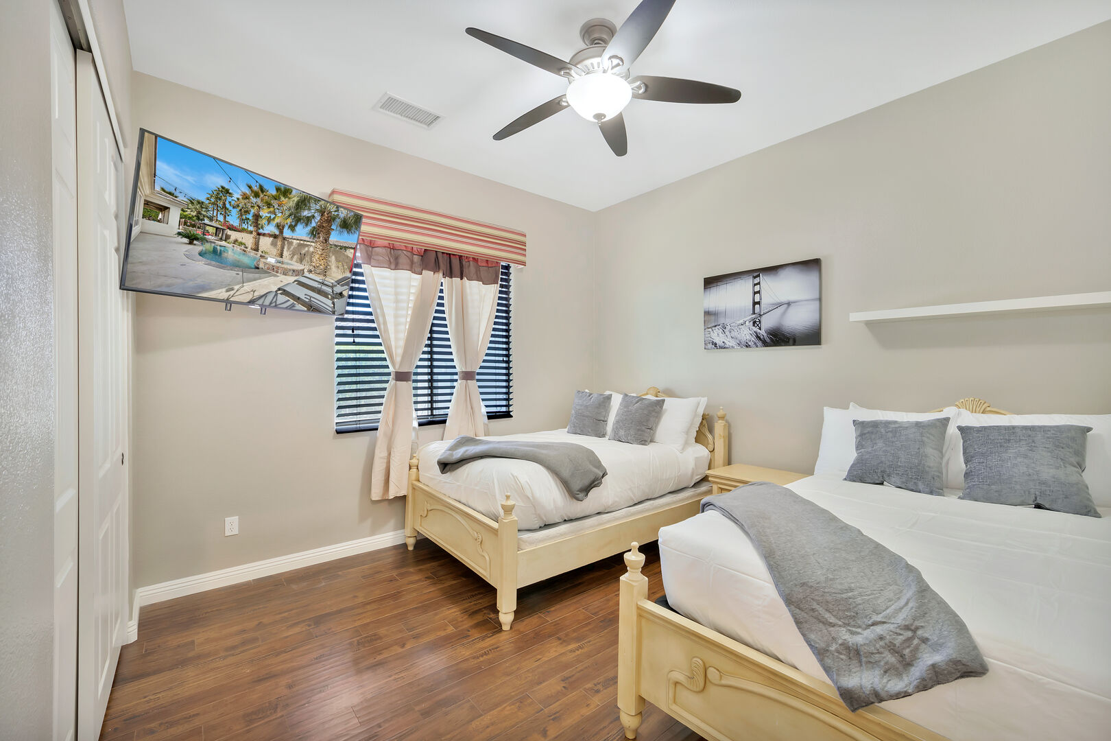 Bedroom 5, located next to the  Laundry Room features two Full-sized beds, 55-inch TCL Smart Television, and ceiling fan. Movie night anyone?