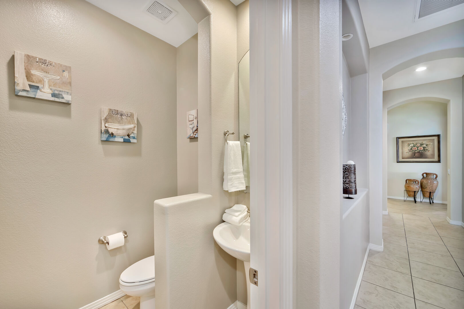 Powder Room 5 is located in the hallway across Master Suite 1 and features a pedestal sink.