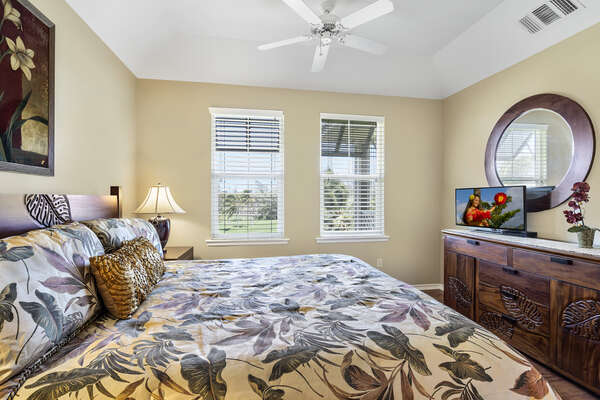 Primary Bedroom with TV and Round Mirror at Waikoloa Hawai'i Vacation Rentals