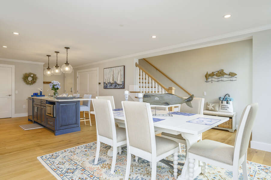 Open concept Dining room and kitchen with stairs to upper level. Unit 202, 557 Route 28, Harwich Port, Cape Cod, New England Vacation Rentals.