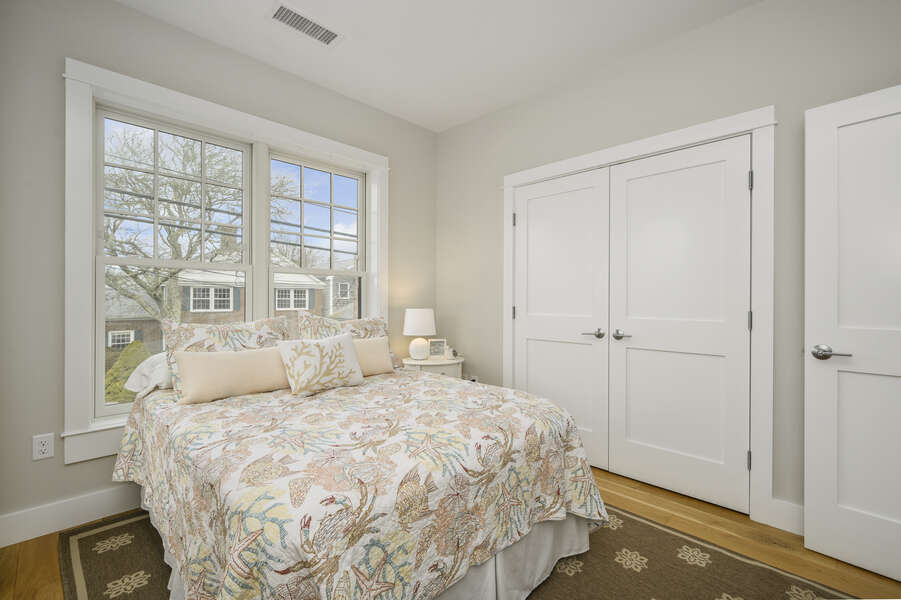 Queen bed with large closet and nightstand with views of Main St. Unit 202, 557 Route 28, Harwich Port,Cape Cod, New England Vacation Rentals
