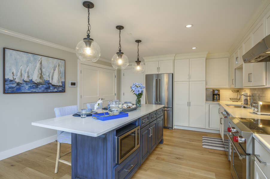 Large luxury style kitchen with center island with microwave, chefs range with oven and stainless fridge. Separate laundry behind the double doors. Unit 204, 557 Route 28 Harwich Port, Cape Cod ,New England Vacation Rentals