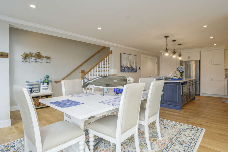 Open concept dining and kitchen area with stairs to the upstairs bonus room. Unit 204, 557 Route 28, Harwich Port, Cape Cod, New England Vacation Rentals