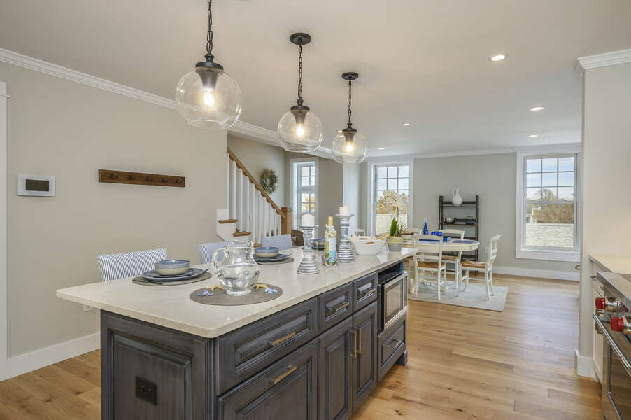 Open concept Kitchen and Dining area with Microwave in center island. Unit 203, 557 Route 28, Harwich Port, Cape Cod, New England Vacation Rentals