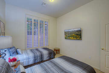 The third bedroom has a TV and side view from the large bedroom window.