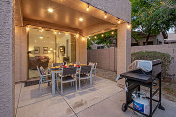 The backyard includes a covered porch with dining furniture and a gas grill for the outdoor chef.