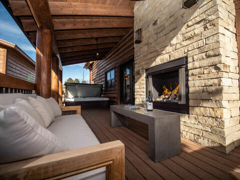 Outdoor patio with hot tub and fireplace
