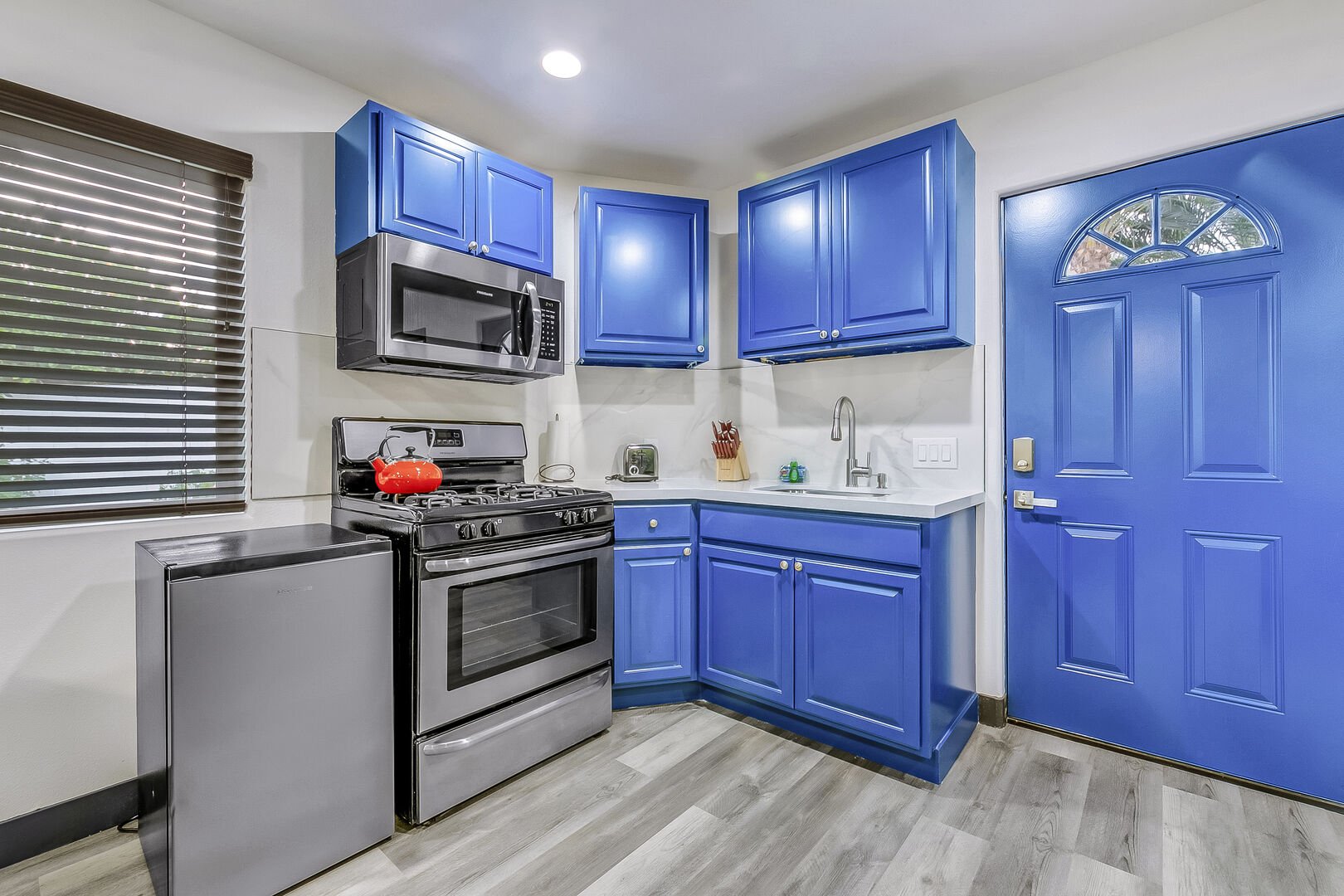 The kitchenette area is well-equipped with a 4-burner range, a built-in microwave, and a sink.