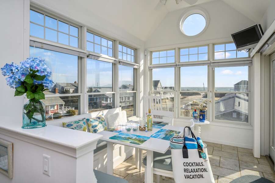 Bright and open concept dining area with panoramic views of the ocean, seating for 6 at the corner dining table with bench seat.27 Fiddlers Green Lane-Dennis Port-New England Vacation Rentals
