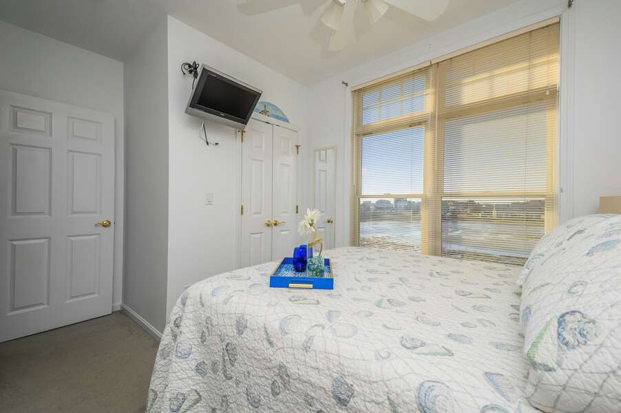 Queen bed with flat screen TV and closet with marsh views  27 Fiddlers Green Lane-Dennis Port-New England Vacation Rentals